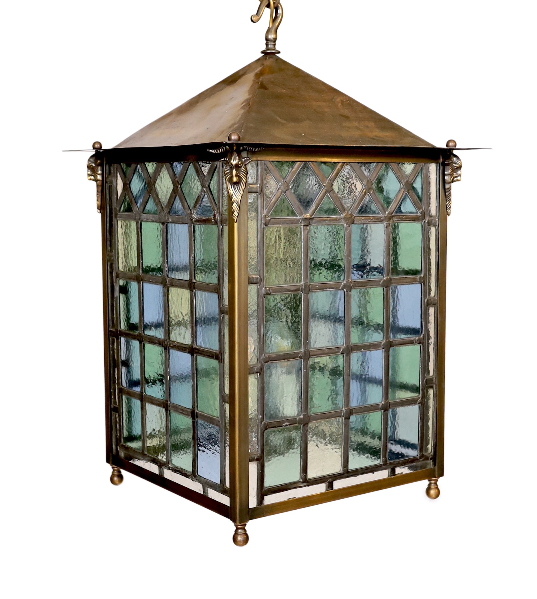 A large Edwardian lacquered brass and leaded glass hall lantern applied with rams head motifs, height 70cm. width 46cm